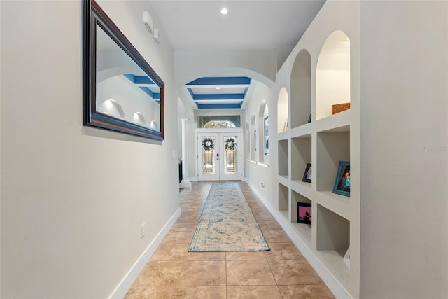 hall with baseboards, built in features, french doors, tile patterned floors, and beamed ceiling