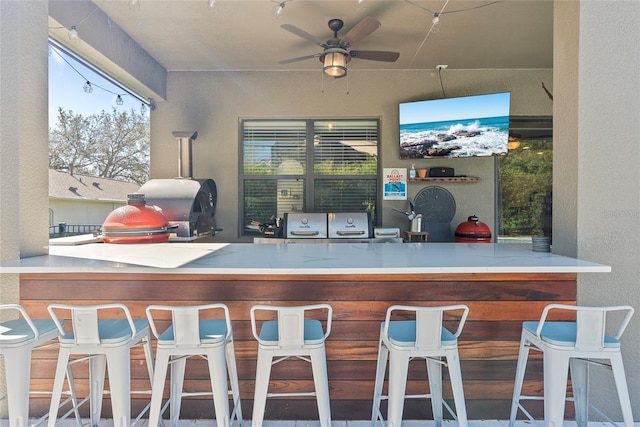 exterior space featuring plenty of natural light, bar area, a ceiling fan, and a textured wall