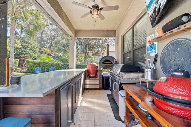 view of patio featuring area for grilling, a grill, and a ceiling fan