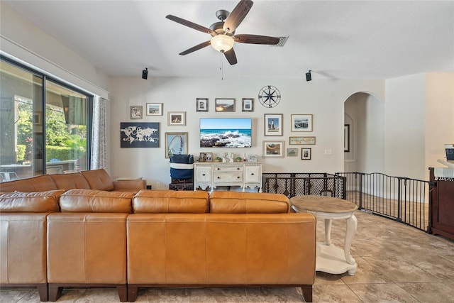 living room with arched walkways and ceiling fan