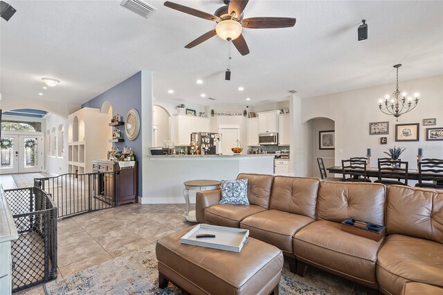 living room featuring arched walkways, light tile patterned floors, recessed lighting, visible vents, and french doors