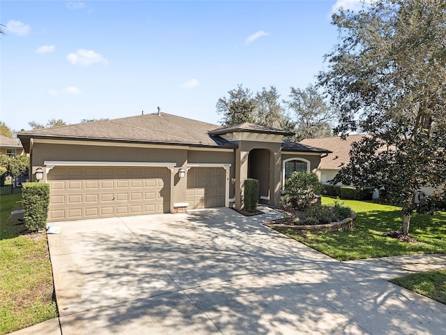 ranch-style home featuring a garage, driveway, a front yard, and stucco siding