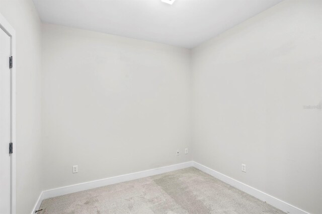 carpeted empty room featuring baseboards
