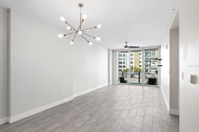 spare room with a wall of windows, wood finished floors, and baseboards