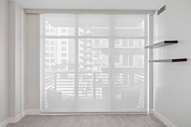interior details featuring visible vents, wood finished floors, and baseboards