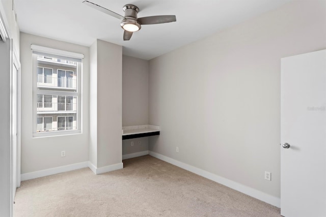 unfurnished bedroom featuring light colored carpet and baseboards