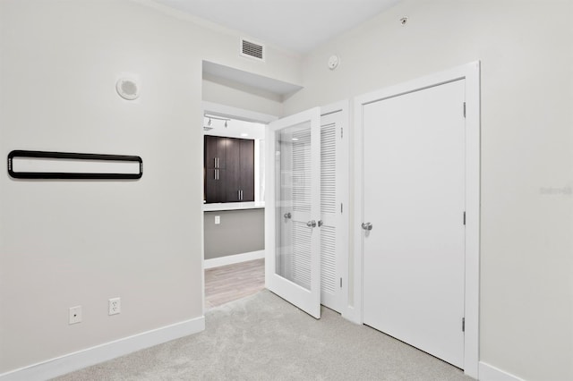 unfurnished bedroom featuring carpet flooring, visible vents, and baseboards