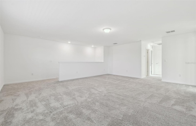 empty room with carpet floors, visible vents, and baseboards