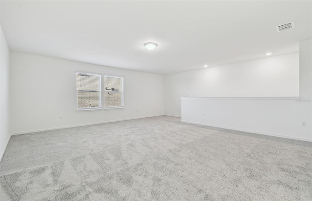 spare room featuring carpet floors, baseboards, visible vents, and recessed lighting