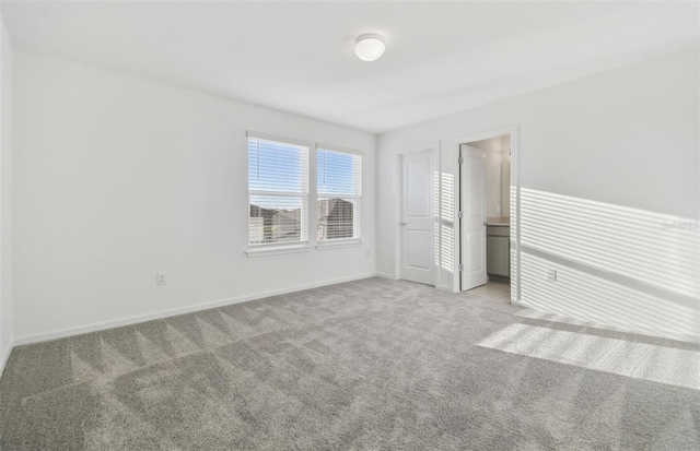 unfurnished bedroom featuring carpet and baseboards