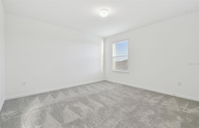 unfurnished room with carpet floors and baseboards