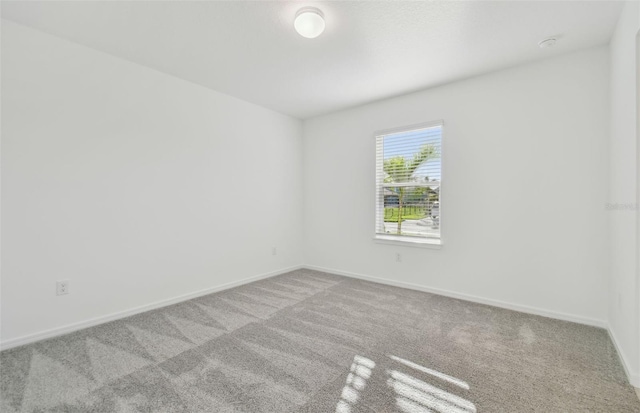 carpeted empty room with baseboards