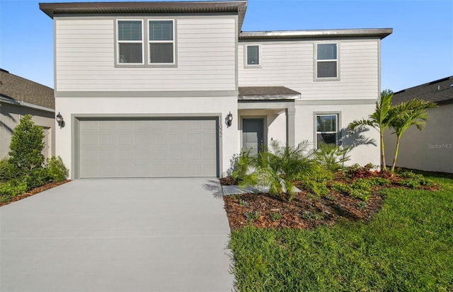 view of front facade featuring concrete driveway, an attached garage, and stucco siding