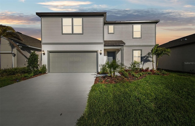 view of front of home with driveway, a front lawn, an attached garage, and stucco siding