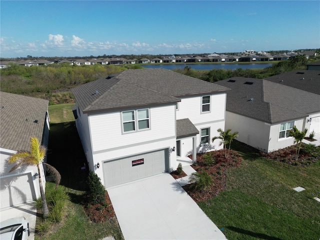 view of front facade featuring a shingled roof, a residential view, concrete driveway, and an attached garage