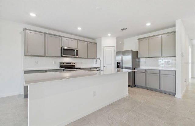 kitchen with a sink, appliances with stainless steel finishes, gray cabinets, and visible vents