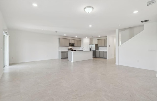 unfurnished living room with visible vents, a sink, and recessed lighting