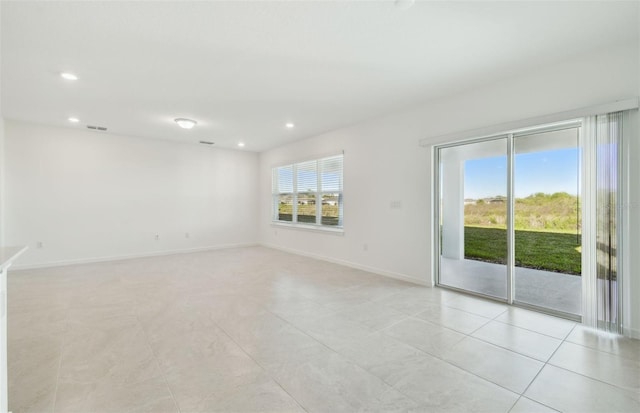 empty room featuring light tile patterned flooring, recessed lighting, visible vents, and baseboards