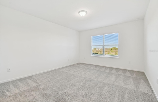 carpeted empty room with baseboards