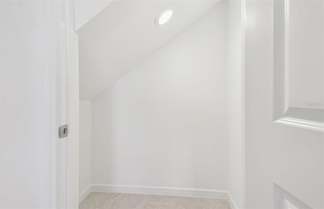 bonus room with vaulted ceiling and baseboards