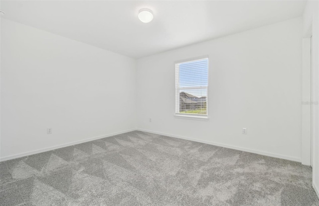 carpeted empty room with baseboards