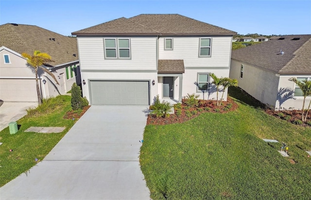 traditional home featuring a garage, a shingled roof, concrete driveway, a front yard, and stucco siding