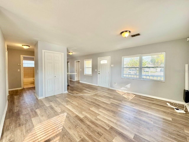 unfurnished living room featuring hardwood / wood-style flooring and plenty of natural light