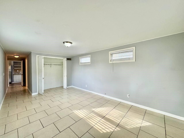 unfurnished bedroom featuring light tile patterned floors and a closet