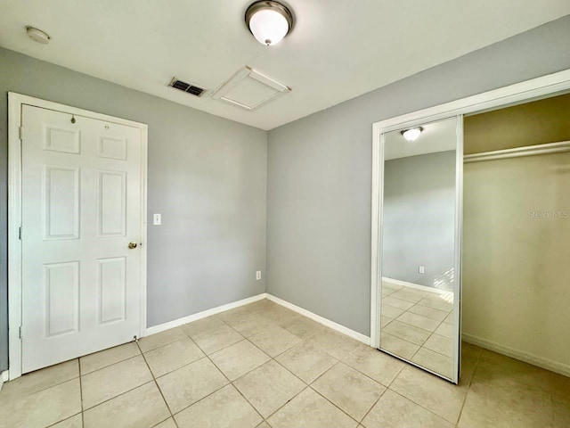 unfurnished bedroom featuring light tile patterned floors and a closet