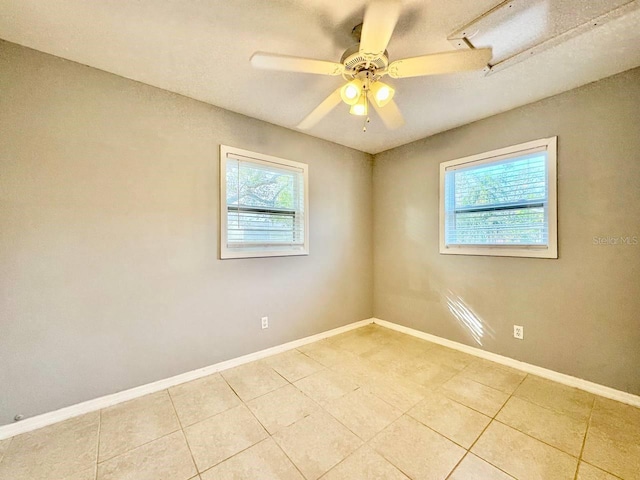 tiled empty room featuring ceiling fan