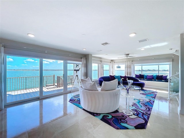 living room featuring ceiling fan, light tile patterned flooring, a water view, and visible vents