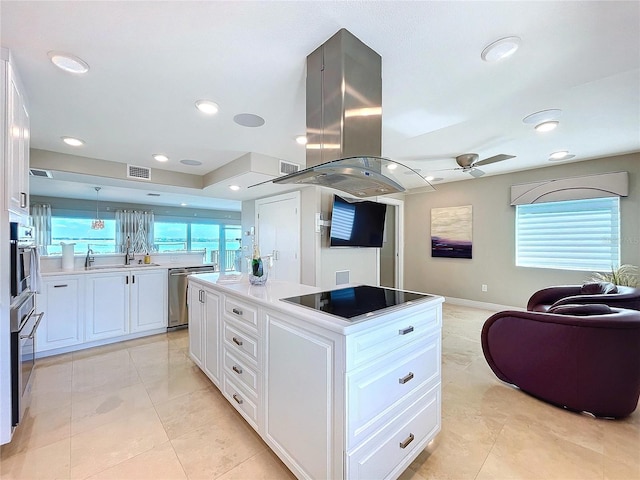 kitchen with visible vents, a center island, island exhaust hood, black electric cooktop, and white cabinetry