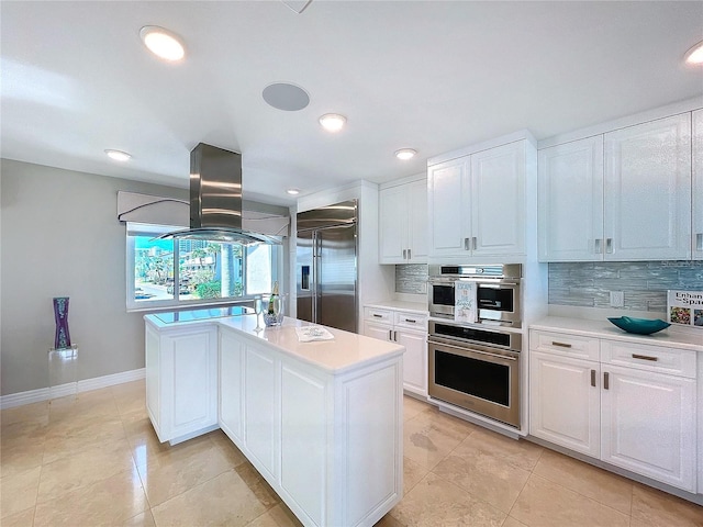 kitchen featuring white cabinetry, island range hood, appliances with stainless steel finishes, and light countertops