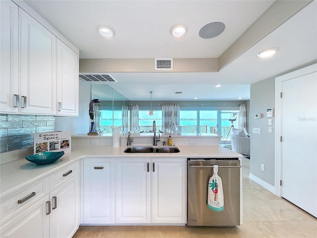 kitchen featuring visible vents, hanging light fixtures, white cabinetry, a sink, and dishwasher