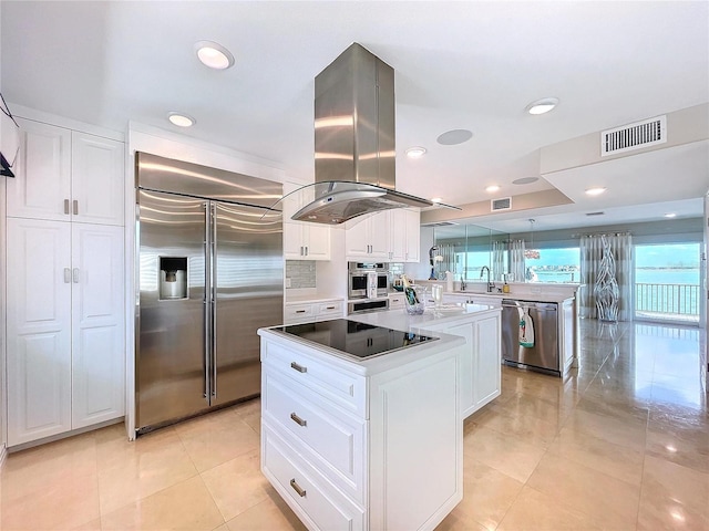 kitchen with island range hood, a kitchen island, appliances with stainless steel finishes, and white cabinets