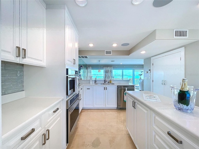 kitchen with light countertops, white cabinets, and visible vents