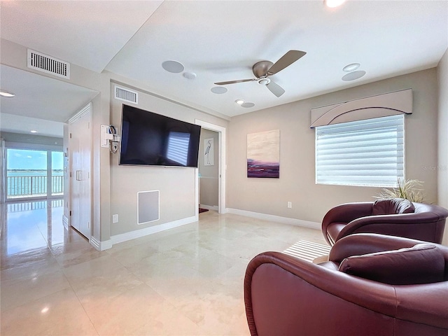 living room with a healthy amount of sunlight, ceiling fan, and visible vents