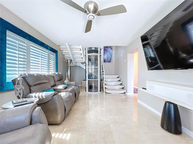 living room featuring a ceiling fan and baseboards