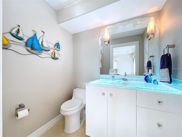 bathroom with toilet, tile patterned flooring, baseboards, and vanity