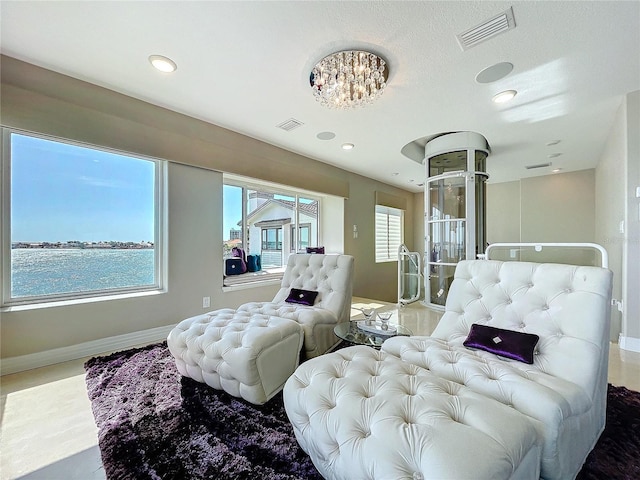 bedroom with a water view, baseboards, and visible vents