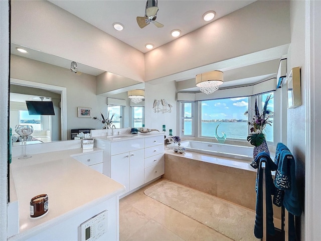 bathroom featuring ceiling fan, tile patterned flooring, a water view, vanity, and a bath