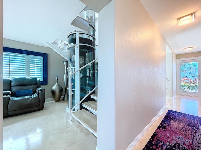 hallway with stairs and baseboards