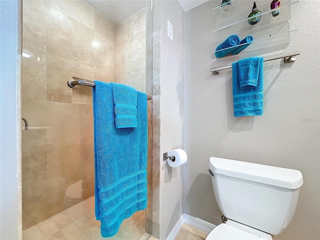 full bathroom featuring tiled shower and toilet