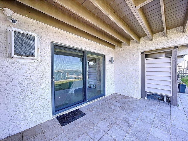 property entrance with a patio and stucco siding