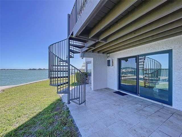 view of patio featuring stairway and a water view