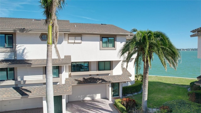 exterior space featuring a garage, a water view, and driveway