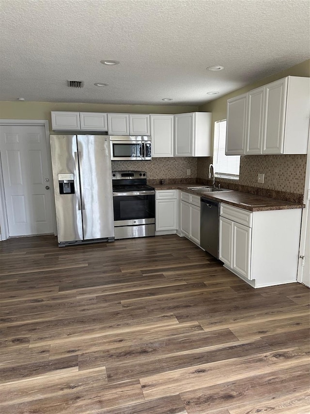 kitchen featuring white cabinetry, sink, dark wood-type flooring, and stainless steel appliances