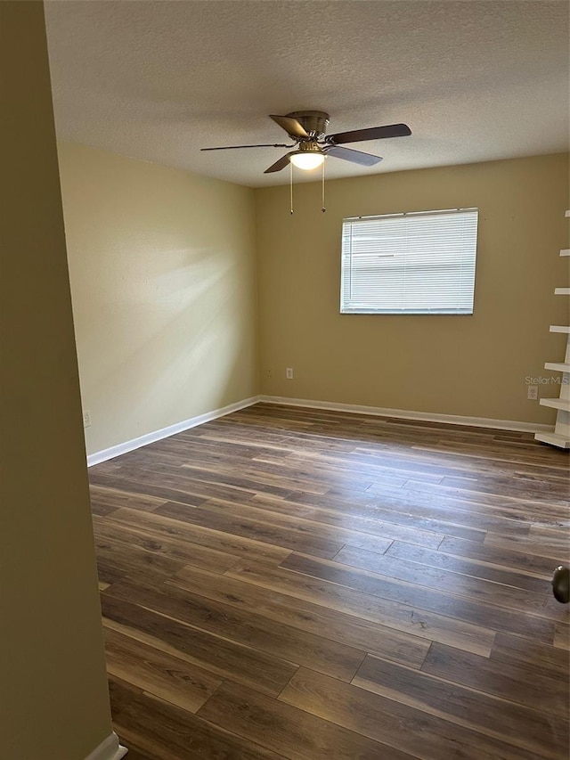 unfurnished room featuring ceiling fan, dark wood-type flooring, and a textured ceiling