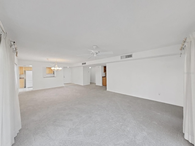 carpeted empty room featuring ceiling fan with notable chandelier