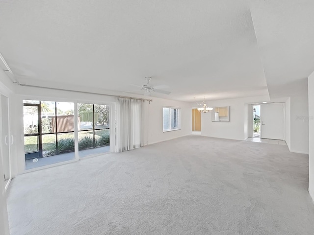 unfurnished living room with carpet floors and ceiling fan with notable chandelier